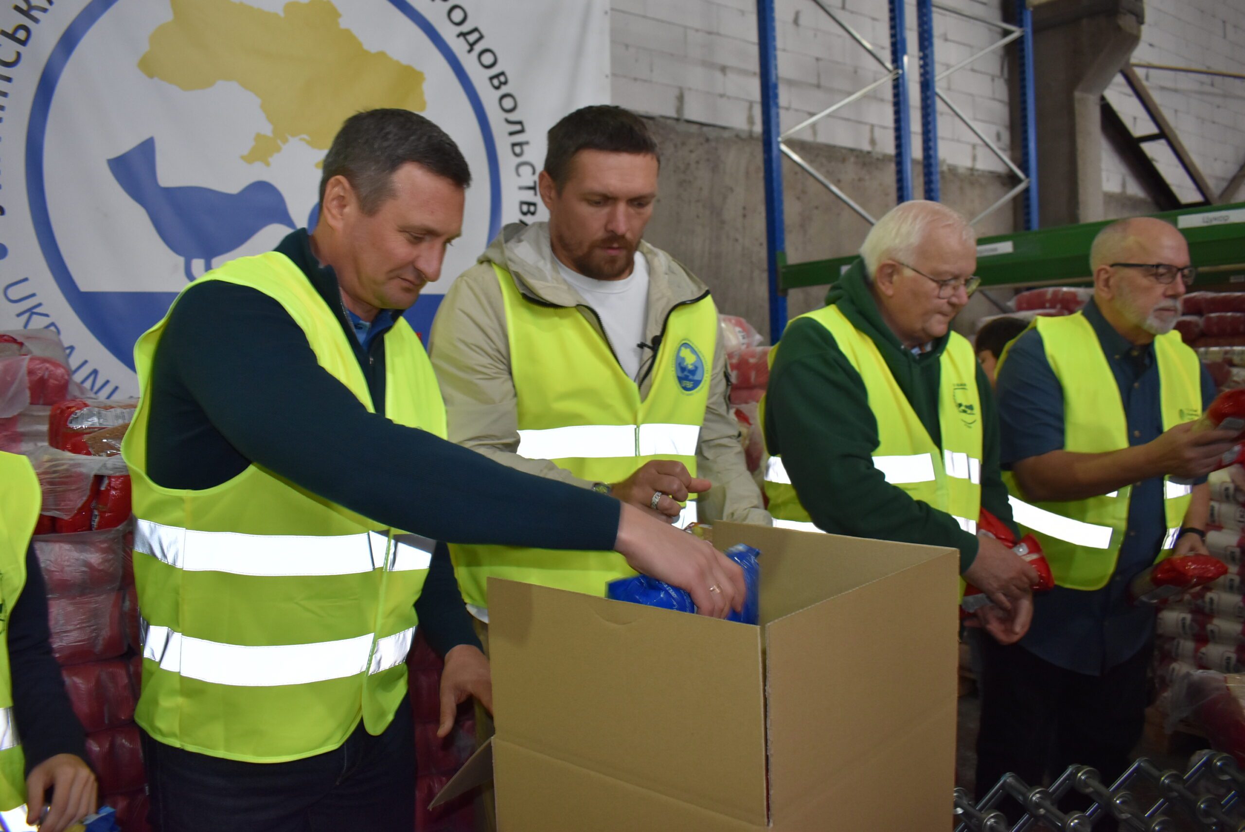 Dmytro Shkrabatovskyi, board chair of the Ukrainian Food Banks Federation; Oleksandr Usyk, a world championship Ukrainian boxer; Jacques Vandenschrik, GFN Board member and president of European Food Banks Federation; and Christopher Rebstock, GFN’s Canada, Europe, and South Asia program director, packed food kits for Irpin, Bucha, and surrounding communities. (Photo: Ukrainian Food Banks Federation)